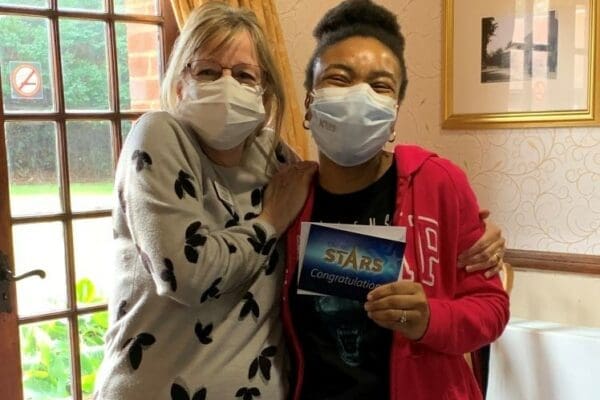 Mellanie being presented with the February Caring Stars Award by Denham Manor Home Manager Jane Jones.