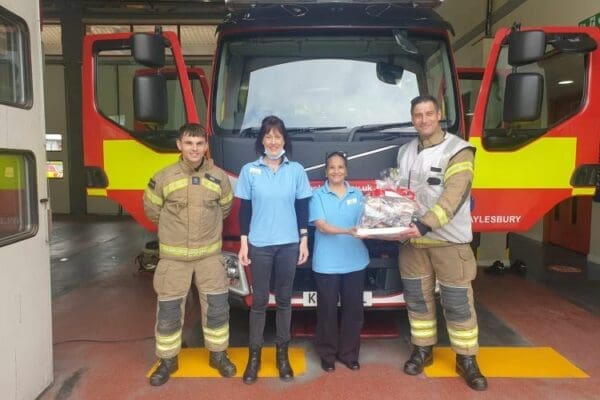 Hulcott Care Home staff standing with local fire fighters in front of their fire engine