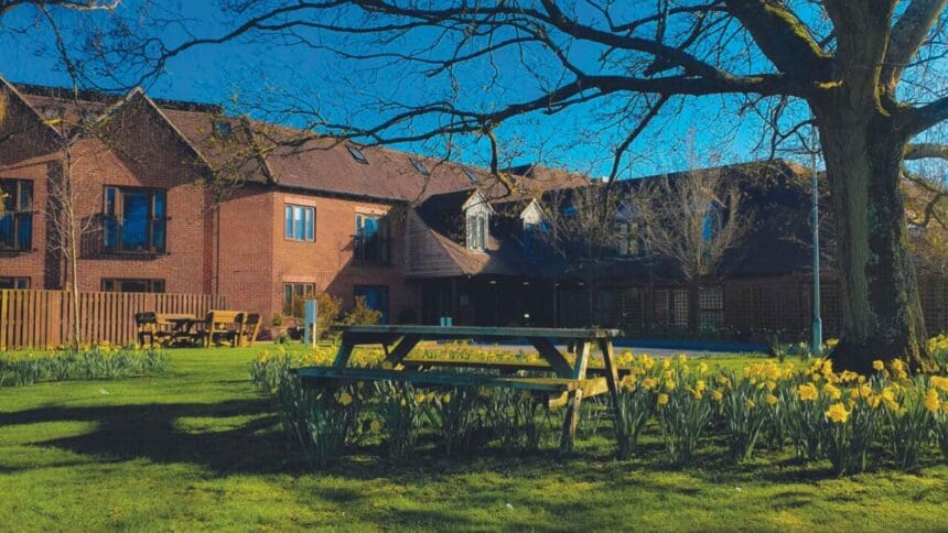 An exterior photograph of Abbeycrest Nursing Home with a picnic bench