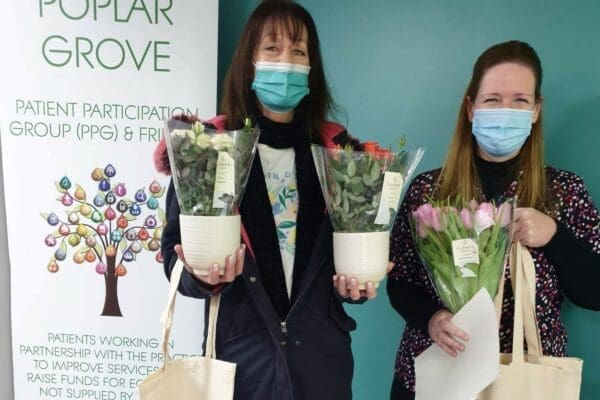 Local stakeholders of Hulcott Care Home holding flowers
