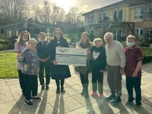 Chloe in activities, Edith, Carolyn, from Ivy Court Care Home, Holly from Age UK, Mollie, Kay, Colin and Anna from Ivy Court with their fundraising cheque from Mollie's 10,000 steps in January challenge.