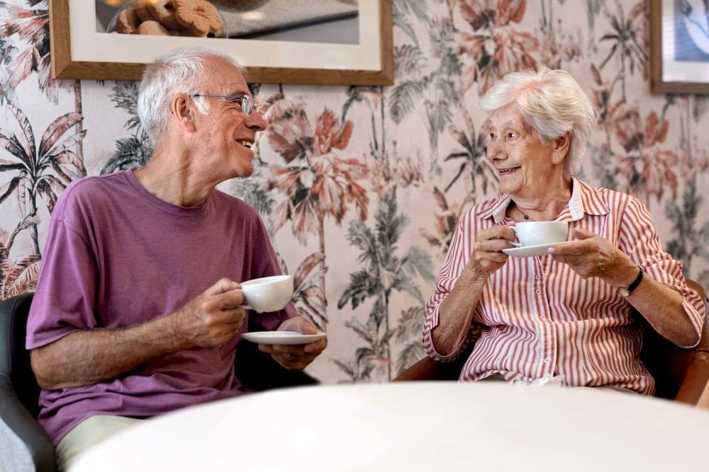 Resident having tea with family member